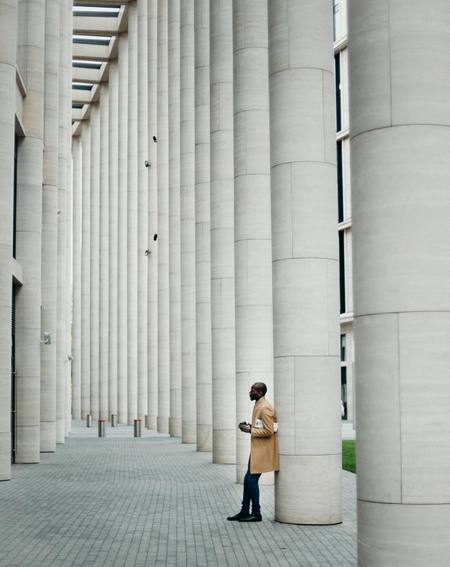 man-leaning-on-post-bored-at-work-millennials